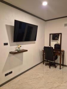 a room with a desk and a television on a wall at New world condo1104 in Ban Chak Phai