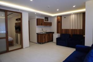 a living room with a blue couch and a kitchen at Dünya Apart in Çaykara
