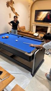 a woman standing next to a pool table at The Verona pool villa Hatyai in Ban Khlong Pleo