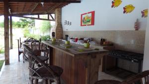 a kitchen with a counter with chairs and a stove at A Toca do Bem-Te-Vi in Águas Belas