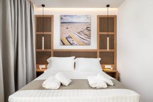 a bedroom with a bed with two white towels at Elysian Beachfront Luxury Suite with Jacuzzi - Sea & City View - ADULTS ONLY in Kos
