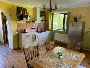 a kitchen with a table and a refrigerator at Viesu nams Purenes in Vecmuiža