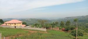 a house on top of a hill with a field at Mirembe house in Mukono