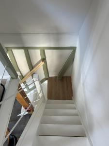 a staircase in a loft with white walls and wooden floors at La maisonnette in Forêt-la-Folie +6 photos