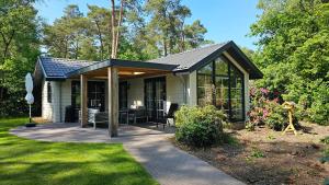a small house with a screened in porch at Bungalow type Korhoen 4p in Otterlo