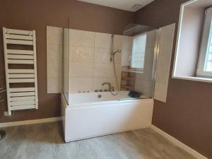 a bathroom with a bath tub and a shower at La Grange Des Roches Roses in Anchenoncourt-et-Chazel