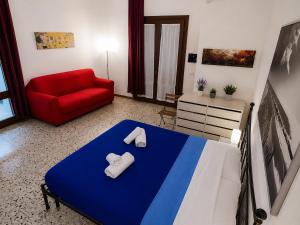 a bedroom with a bed and a red couch at Il Giardino su Lido Burrone in Favignana