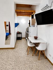 a small kitchen with a white table and chairs at Il Giardino su Lido Burrone in Favignana +17 photos