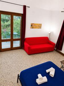 a red couch and a blue bed in a room at Il Giardino su Lido Burrone in Favignana