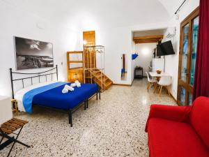 a bedroom with a blue bed and a red couch at Il Giardino su Lido Burrone in Favignana