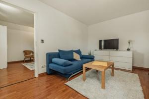 a living room with a blue couch and a tv at Haus Teltow in Teltow
