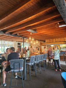 a group of people sitting at tables in a restaurant at Bungalow type Korhoen 4p in Otterlo