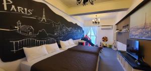 a bedroom with a couch and a wall with a mural at 仲夏墾丁親子民宿 in Nanwan