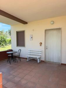 a patio with a bench and a table and a door at Agriturismo Bufaleria in Scanzano