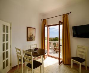 a dining room with a table and chairs and a balcony at Kaminia Holiday Homes in Éxo Goniá
