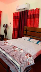 a bedroom with a bed with red curtains at Prime Stay in Multan