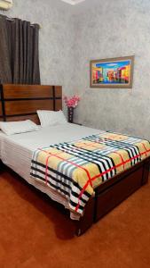 a bedroom with a bed with a blanket on it at Prime Stay in Multan