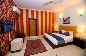 a bedroom with a bed with an orange stripe wall at Prime Stay in Multan