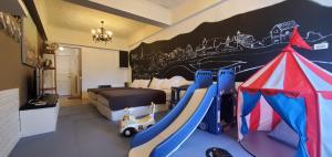 a bedroom with a bed and a play room with a slide at 仲夏墾丁親子民宿 in Nanwan