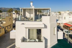 a white house with a view of a city at Elysian Beachfront Luxury Suite with Jacuzzi - Sea & City View - ADULTS ONLY in Kos