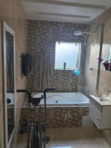 a bathroom with a bath tub and a cat standing next to a shower at Sobral hostel in Magalhães Bastos