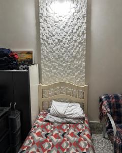 a small bedroom with a bed and a wall at Sobral hostel in Magalhães Bastos