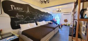 a bedroom with a bed with a mural on the wall at 仲夏墾丁親子民宿 in Nanwan +27 photos