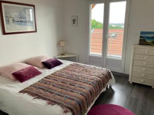 a bedroom with a large bed and a window at Les Hauts de Bassens in Bassens