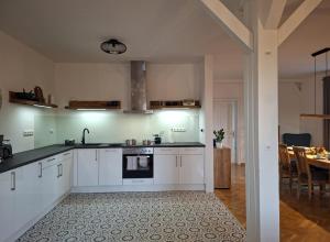 a kitchen with white cabinets and a dining room at Holiday Apartment Henry - Auszeit unter alten Balken in Arnstadt