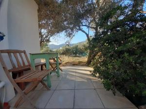 a table and a bench sitting on a patio at Kampos Rooms in Palaiochora +32 photos