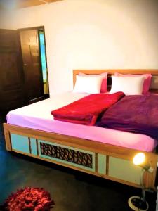 a bedroom with two beds with red sheets at Green Mountain Cabin in Nuwara Eliya