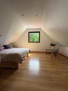 a bedroom with a bed and a desk and a window at Stolove Chatki Radków in Radków