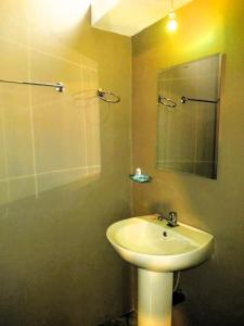 a bathroom with a sink and a mirror at Green Mountain Cabin in Nuwara Eliya