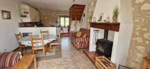 a kitchen and living room with a table and a stove at Gîtes le clos du verger avec piscine chauffée commune in Maurens