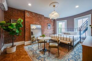 a bedroom with a brick wall and a bed and a table at The Concord Hotel in Boston