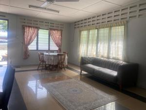 a living room with a couch and a table at Warisan Homestay B in Mersing +19 photos