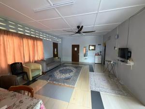 a living room with a couch and a ceiling fan at Warisan Homestay B in Mersing