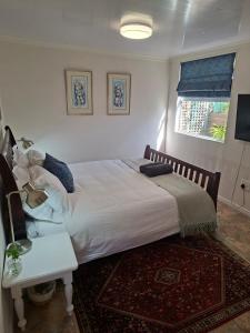 a bedroom with a bed and a table and a window at Hope Street Studio in Kuilsrivier