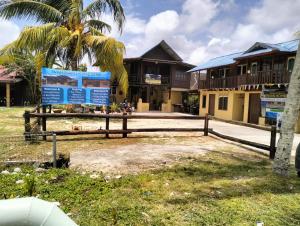 a sign in front of a building with a palm tree at Warisan Homestay B in Mersing
