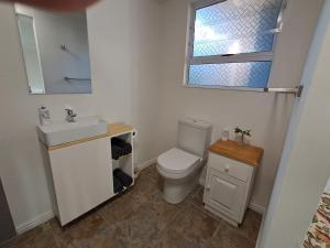 a bathroom with a toilet and a sink and a window at Hope Street Studio in Kuilsrivier +15 photos