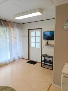 an empty room with a door and a television at Majoitus Kulma 2 in Ilomantsi