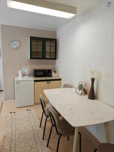 a kitchen with a white table and chairs in a room at Majoitus Kulma 2 in Ilomantsi