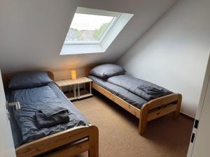 two beds in a room with a window at Steilsand 1 - 200 M Zum Strand in Cuxhaven