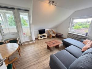 a living room with a couch and a table at Steilsand 1 - 200 M Zum Strand in Cuxhaven