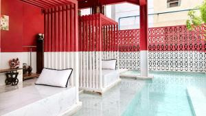 a pool with two pillows next to a red and white wall at Talakkia Boutique Hotel in Bangkok