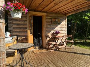 a porch of a cabin with a table and chairs at Salatse metsaonn in Salatse