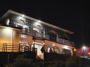 a building with two balconies on it at night at Himalayan due homestay chopta in Sari
