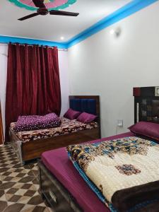 a room with three beds and a ceiling fan at Himalayan due homestay chopta in Sari