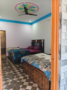 a room with two beds and a clock on the wall at Himalayan due homestay chopta in Sari
