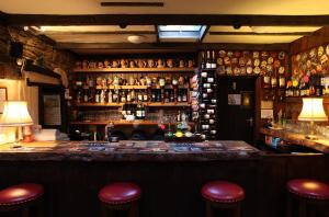 eine Bar mit roten Hockern in einem Zimmer mit Flaschen in der Unterkunft The Rockford Inn in Lynton